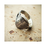Markanter Messing-Key-Ring auf altem beigen Autolack, Vintage-Look.