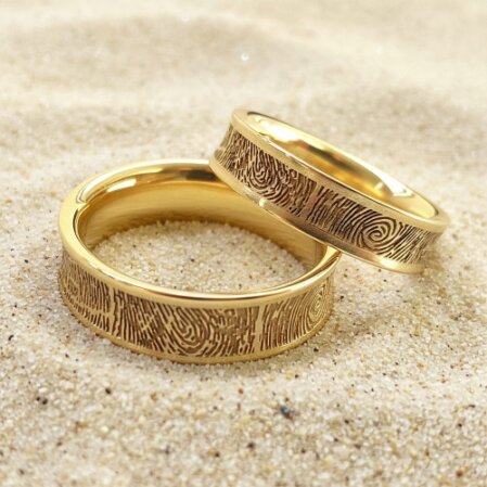 Goldene Trauringe mit Fingerabdruck Struktur und individueller Oberfläche